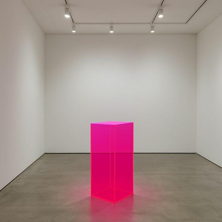 Translucent neon pink display plinth in an exhibition room.