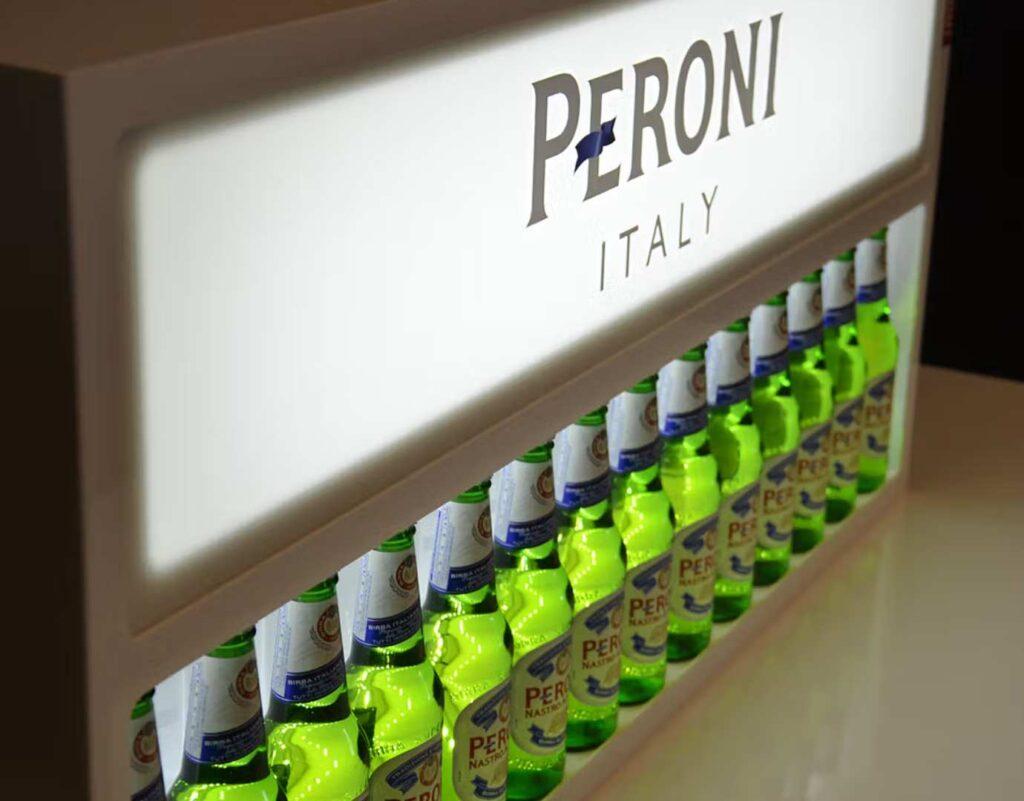 A large bottle glorifier unit with Peroni branding and bottles on display.