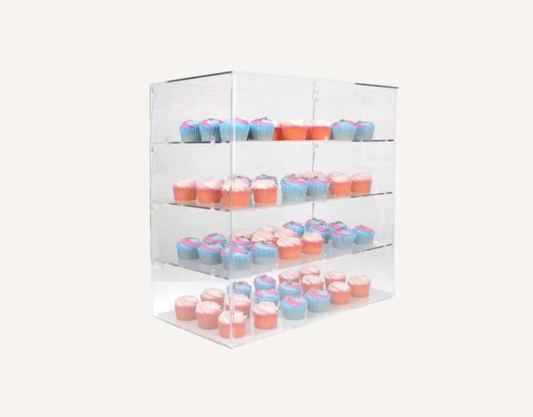 An acrylic cake display case with shelving.