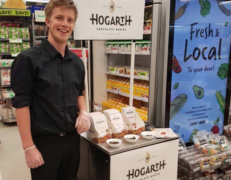 A man standing smiling next to a product testing booth.
