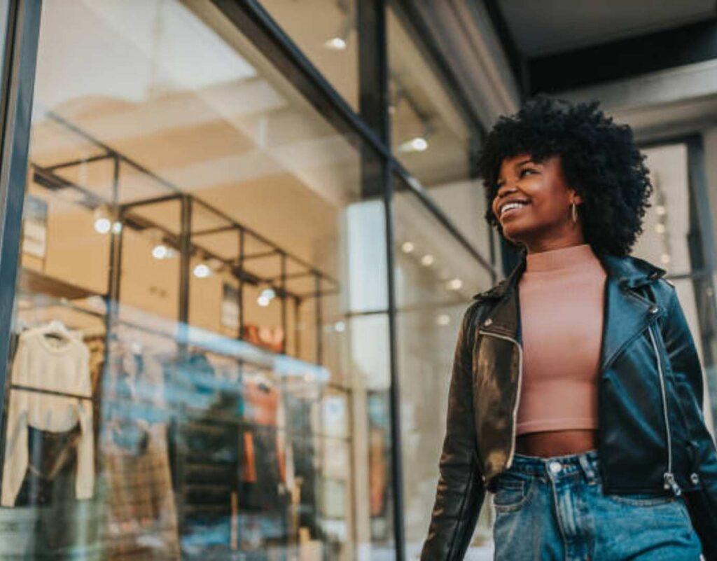 A woman smiling outside of a shop.