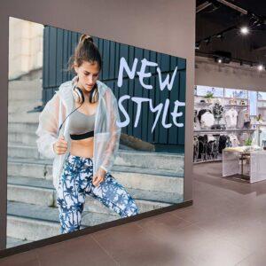 An indoor direct view GOB LED video screen on a clothing shop wall.