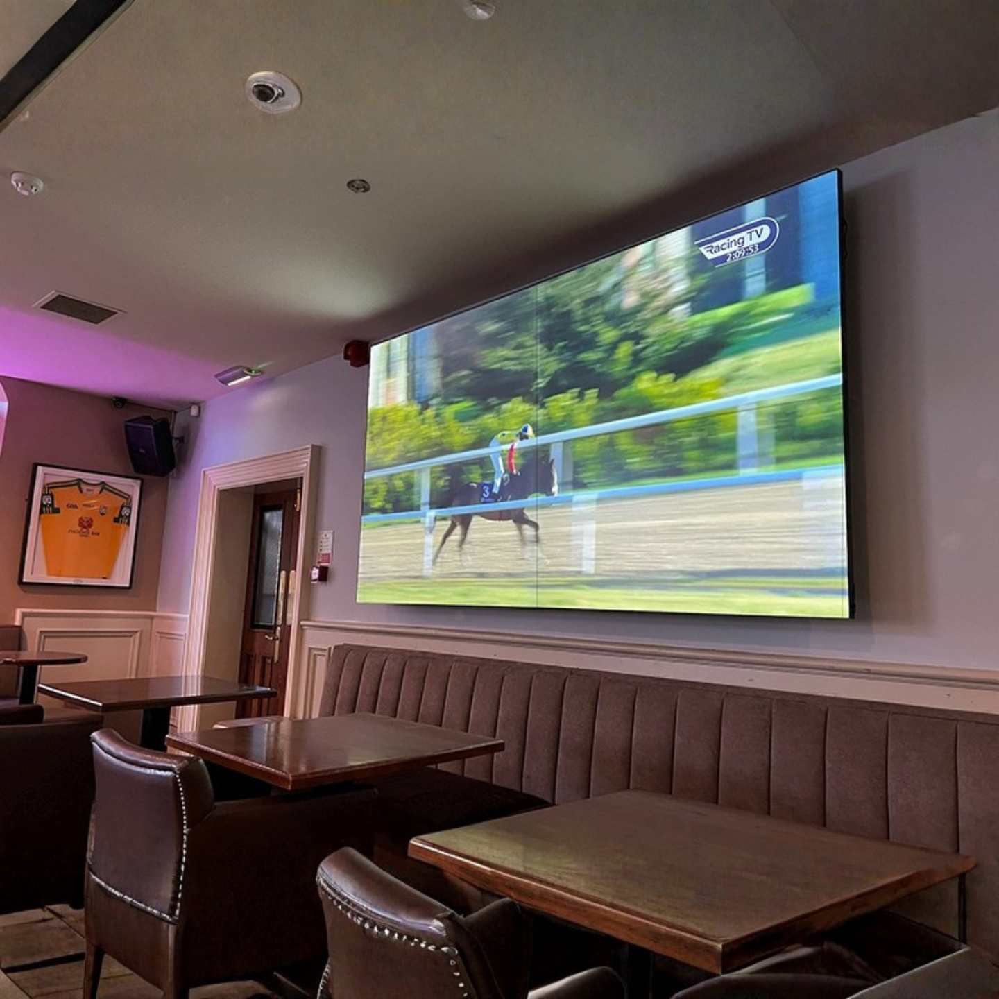 An ultra narrow bezel LCD video wall display on a wall inside a pub.