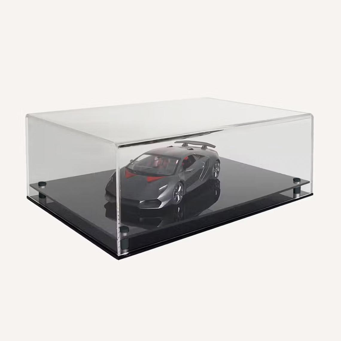 Clear rectangular acrylic display case showcasing a sleek silver model on a glossy black base, photographed against a light background.
