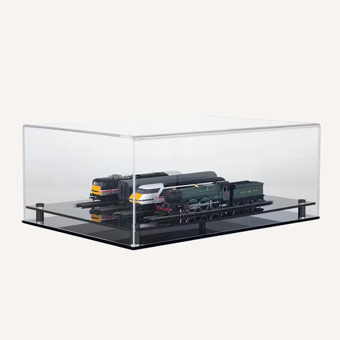 Clear acrylic rectangular display case featuring two detailed models on parallel tracks mounted on a glossy black base, set against a light background.