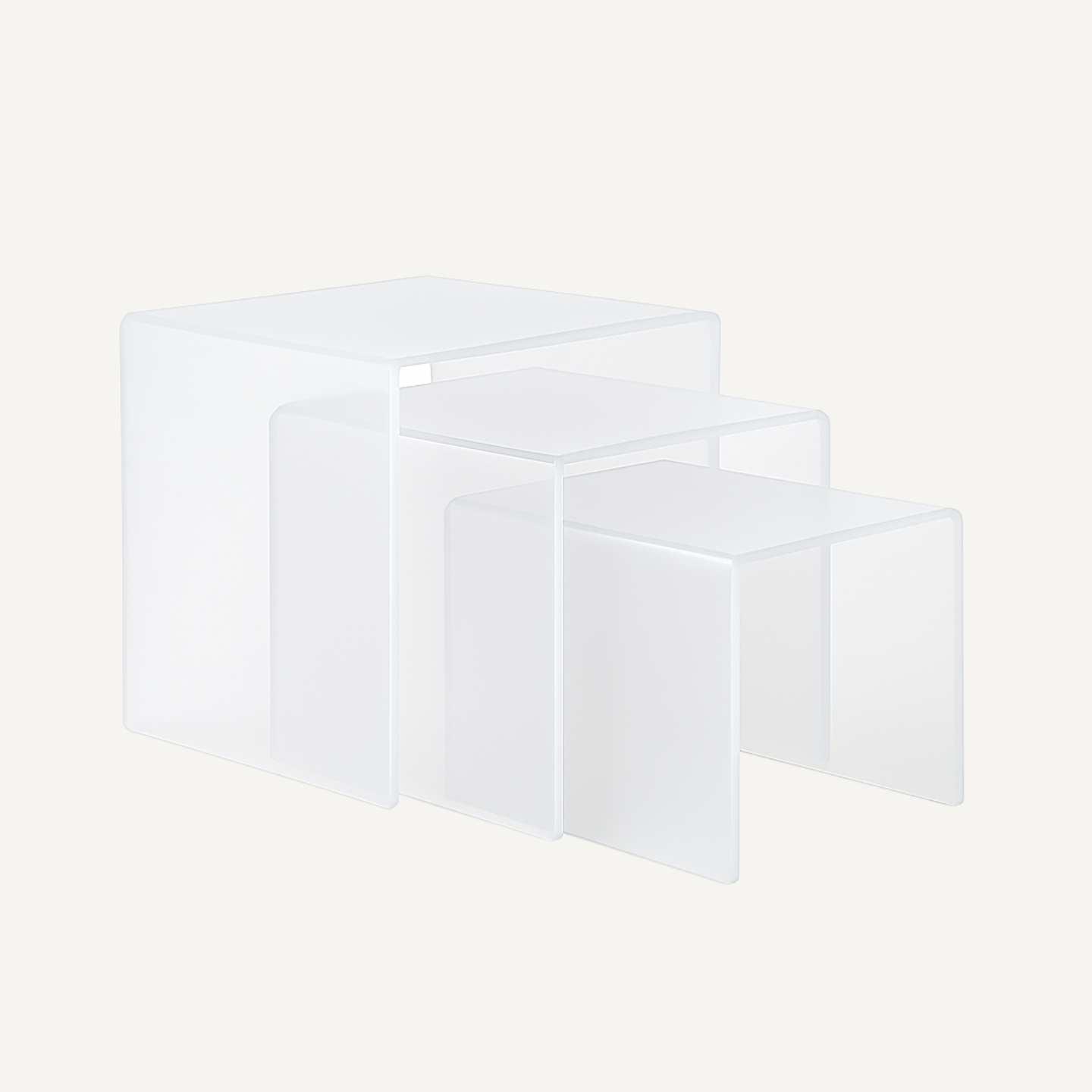 A set of three polar frosted coloured acrylic nesting tables.