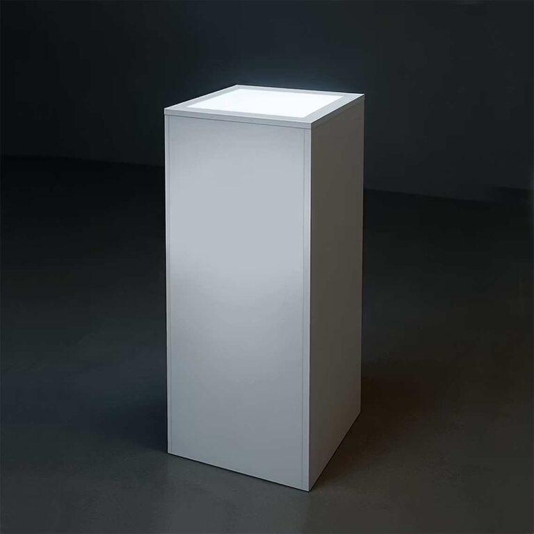 A mains-powered white flat pack display plinth with illuminated top.
