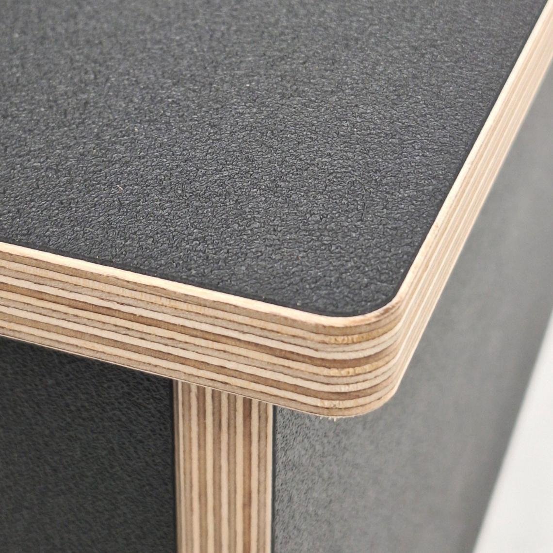 Close-up of the adjustable plywood rear wheel support on the bike display podium, showing curved black melamine panels and slidable mounting slots.