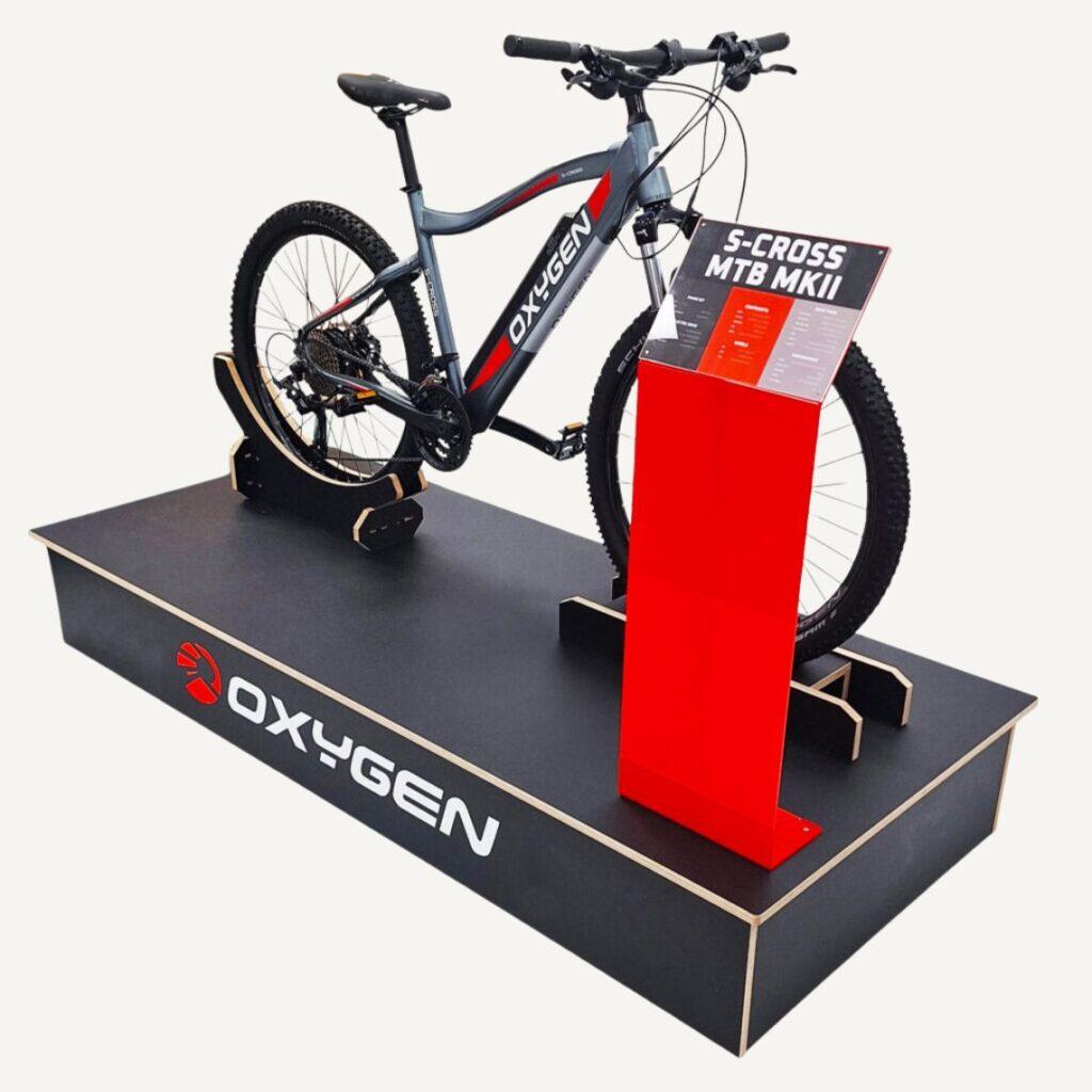 An adjustable, bespoke bike display stand for retail and sports shops. Featuring a magnetic graphics trap and adjustable stand to suits a wide variety of bikes.