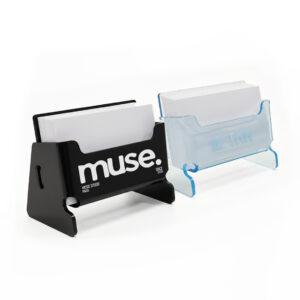 Two branded acrylic business card holders on a white background: one in black with ‘muse’ printed on the front, and one in transparent blue, both displaying stacks of business cards.