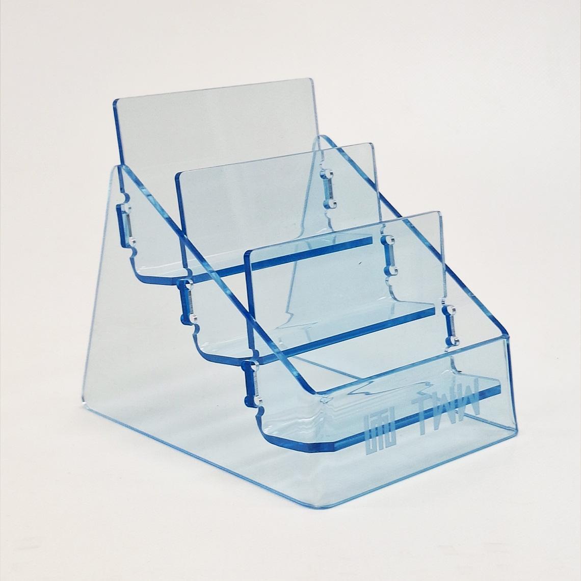 Transparent blue acrylic business card display holder featuring multiple stepped compartments for displaying business cards.