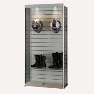A slatwall display cabinet with spotlights and helmets and boots on display.
