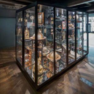A large, black framed glass display case with different objects inside.