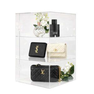 Acrylic display cabinet with purses and perfume on display.