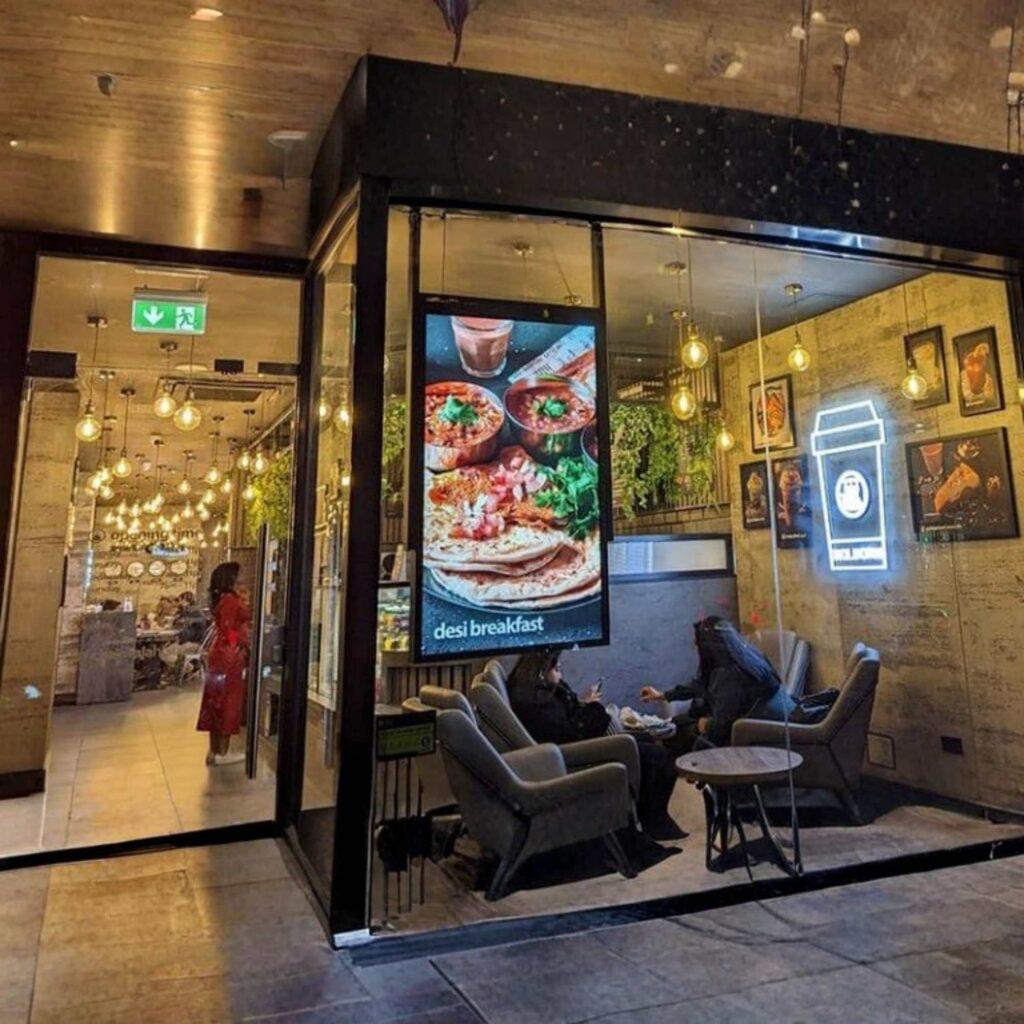 A restaurant with a ceiling hanging window digital screen.