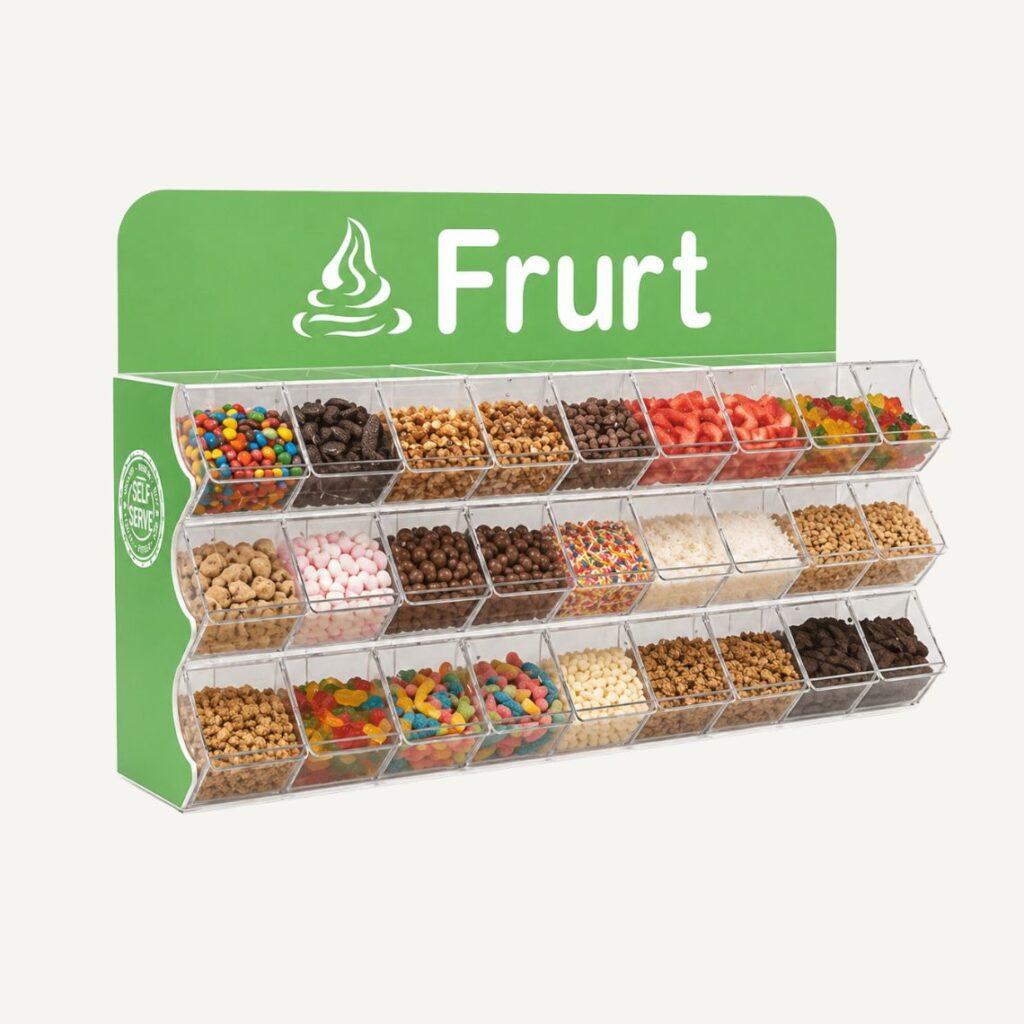 Fully stocked frozen yogurt toppings display with clear bins and branded Frurt header for retail self-serve environments.