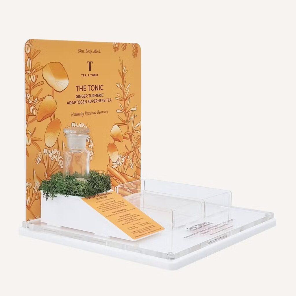 A bespoke countertop tea glorifier for Tea & Tonic, with colourful, yellow branding.