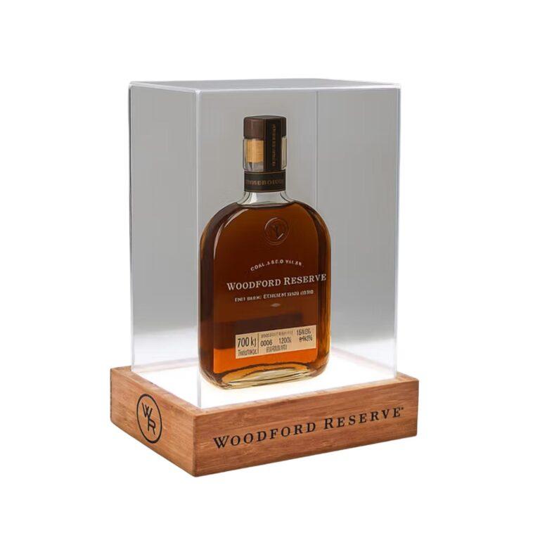 A custom illuminated drinks display plinth with a bamboo base and protective cover with a whiskey bottle sat inside.